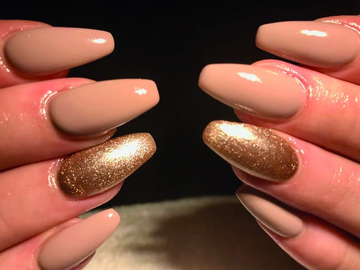 Nude coffin nagels met een gouden glitteraccent